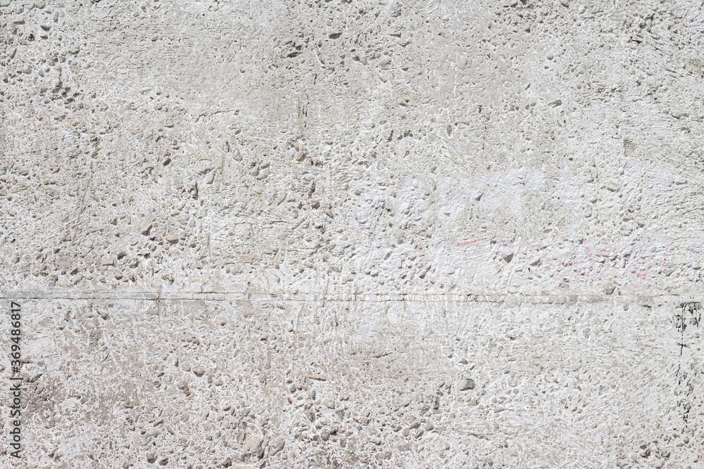 Concrete with rocks wall bumpy grey painted surface for cool urban grungy wallpaper or background Concrete with rocks wall bumpy grey painted surface for cool urban grungy wallpaper or background