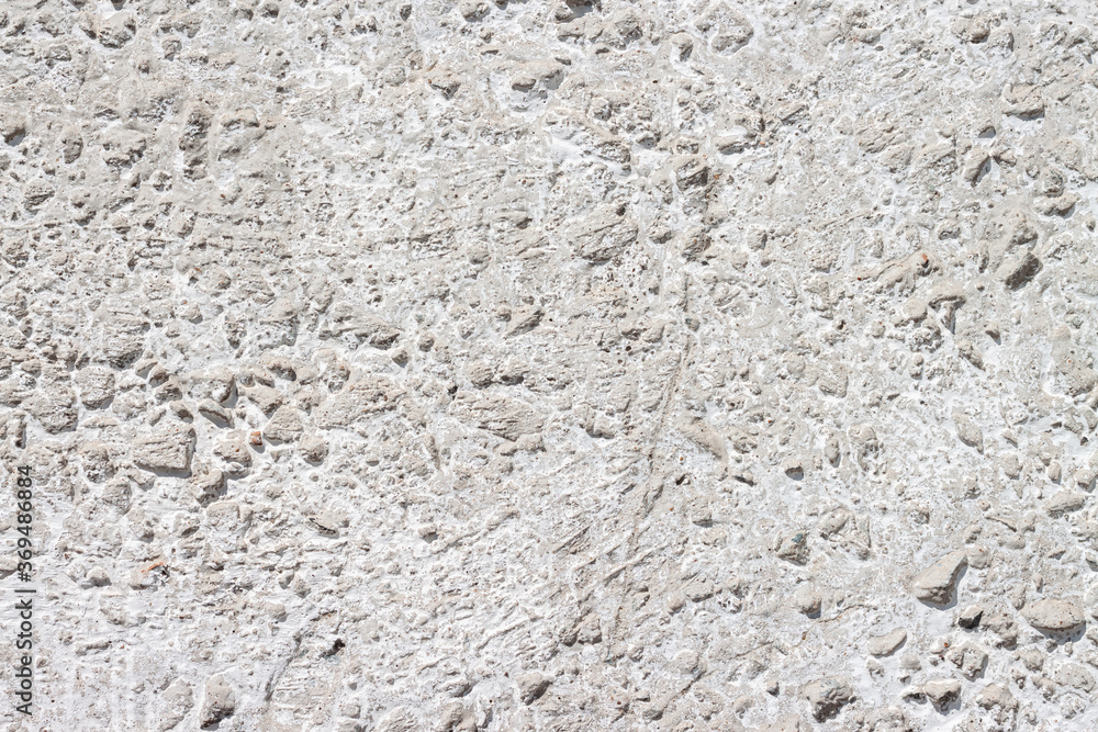 Concrete with rocks wall bumpy painted surface for cool urban grungy wallpaper or macro background Concrete with rocks wall bumpy painted surface for cool urban grungy wallpaper or macro background