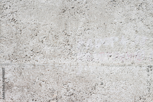 Concrete with rocks wall bumpy grey painted surface for cool urban grungy wallpaper or background