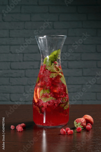 Wallpaper Mural Glass decanter with red berry cocktail on a wooden table with raspberries and strawberries. Photos for restaurant, cafe and bar menus Torontodigital.ca