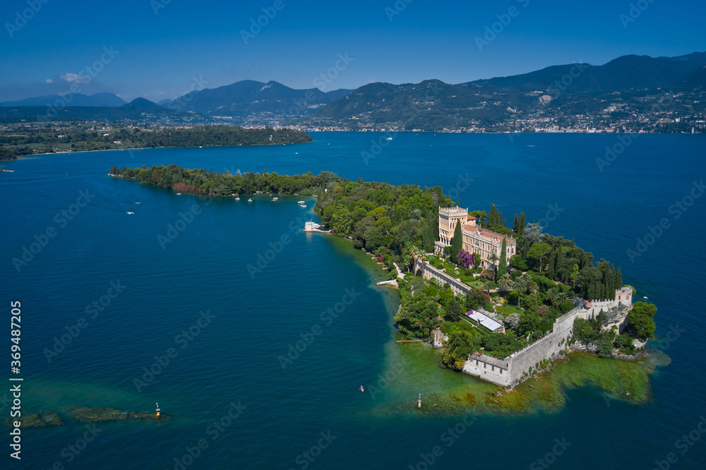 Aerial view of the island Garda, Lake Garda, Italy Aerial photography. Is the biggest island on Lake Garda. In the background Alps, blue sky.