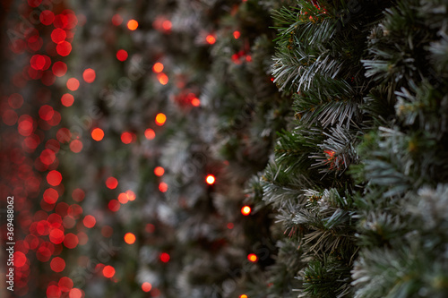 Christmas New Year background ov fir-tree and red blurred bokeh lights