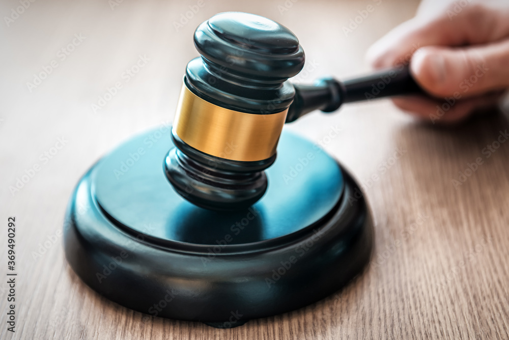 hand holds judge's gavel hand holds judge's gavel