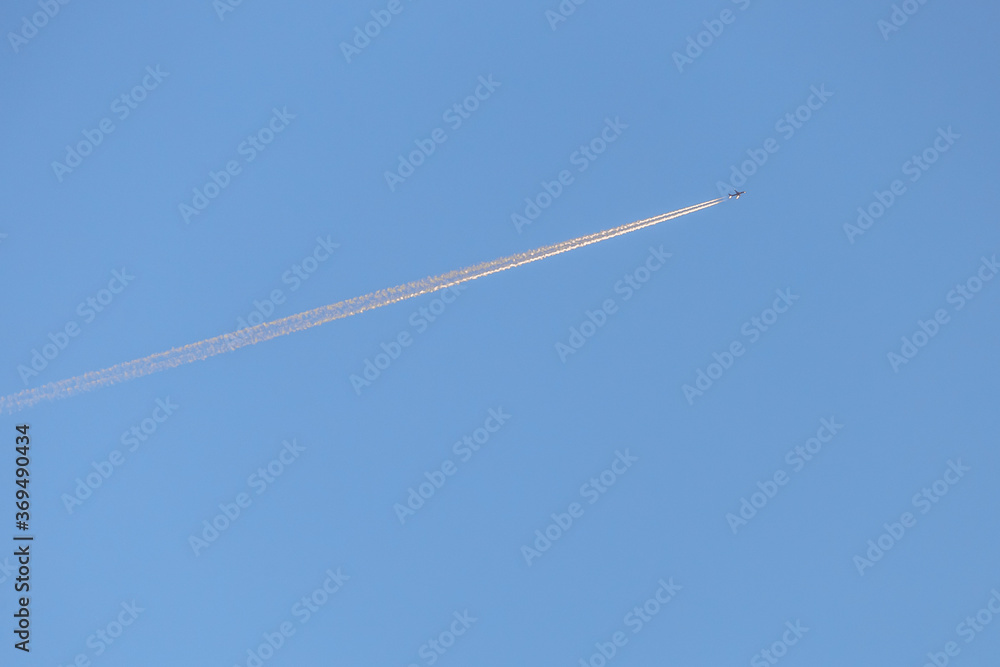 Flying airplane trail in a clear sky Flying airplane trail in a clear sky