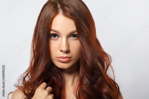 beauty portrait of a young red-haired woman on white background.