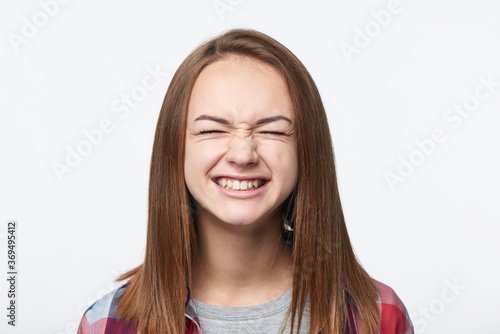 Happy emotional teen girl closing her eyes tight