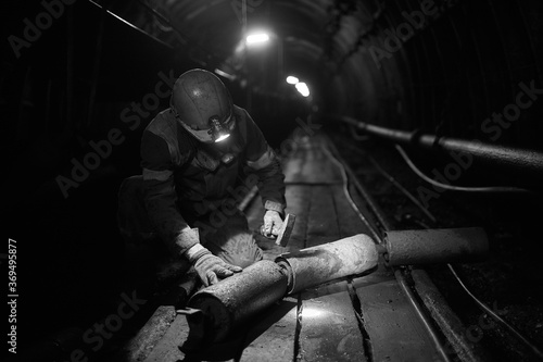 Silhouette of a working miner in a mine