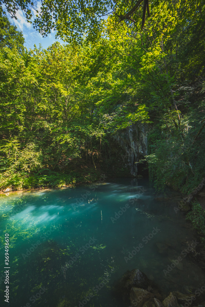 Obraz premium Krupajsko Vrelo (The Krupaj Springs) in Serbia, beautiful water spring with waterfals and caves. Healing light blue water.