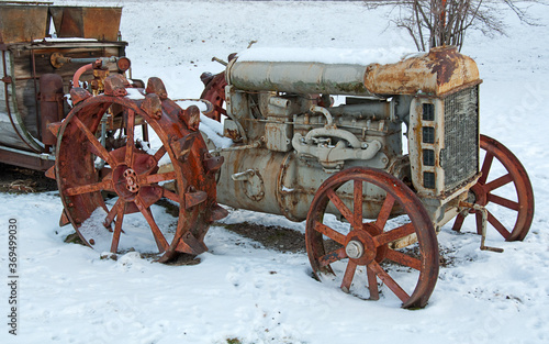 Obraz na plátně Rusty antique farm tractor in snow