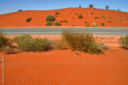 Horizontal image of a road passing through red landscape