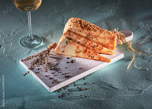 Sliced cheese with herbsand wine on wooden cutting-board photo