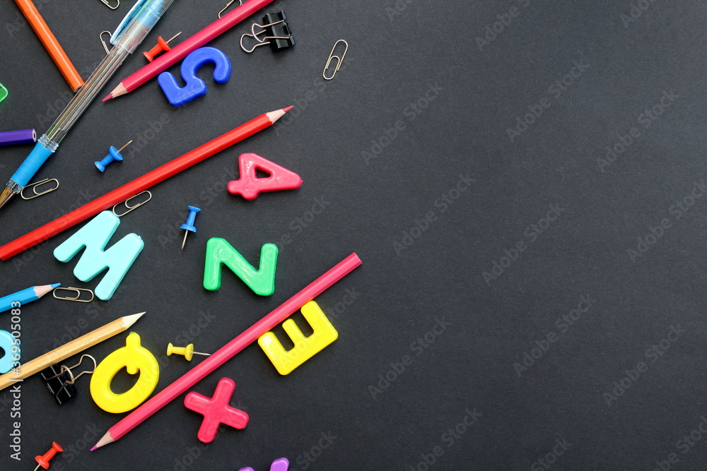 English letters and stationery for school on black background with place for text English letters and stationery for school on black background with place for text