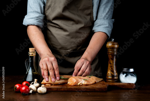 Canvas Print The cook poured oil on the chicken breast