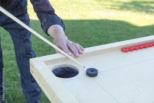 Man playing Novuss in outdoors. Novuss is a national sport in Latvia similar to pocket billiards or pool. photo