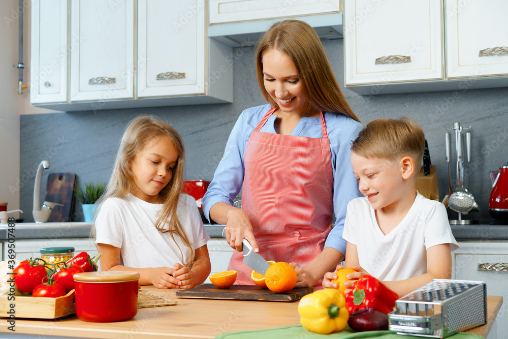 Mother cooking with her children in kitchen Mother cooking with her children in kitchen