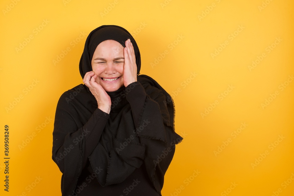 Doleful desperate crying Middle aged muslim woman wearing black hijab being in depression after quarrel with wife or girlfriend, looks stressfully, frowns face, . Woman feels lonely and anxious