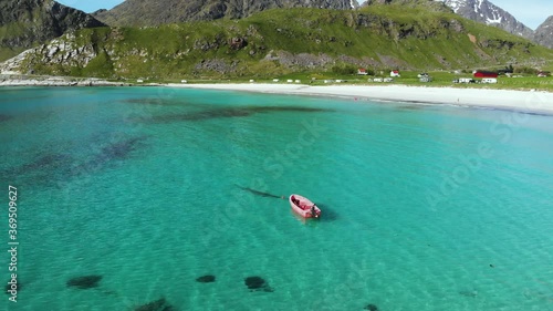 Red boat hovering over turquoise  Water in Lofoten Norway