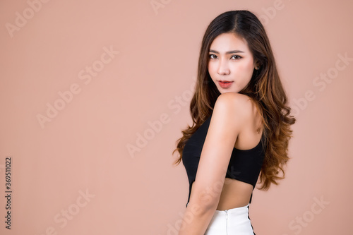 Beautiful Asian woman wear dress pants black. Standing in front of a pink background.