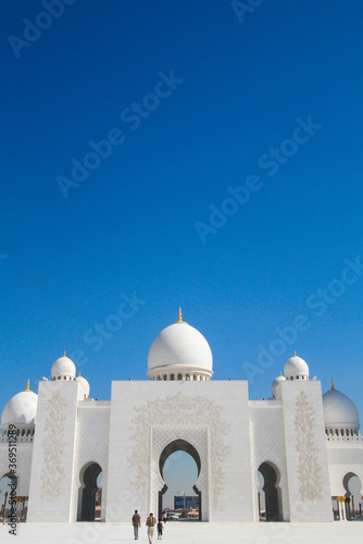 Mosque Sheikh Zayed bin Sultan Al Nahyan ABU DHABI. The gate and white domes against the blue sky photo
