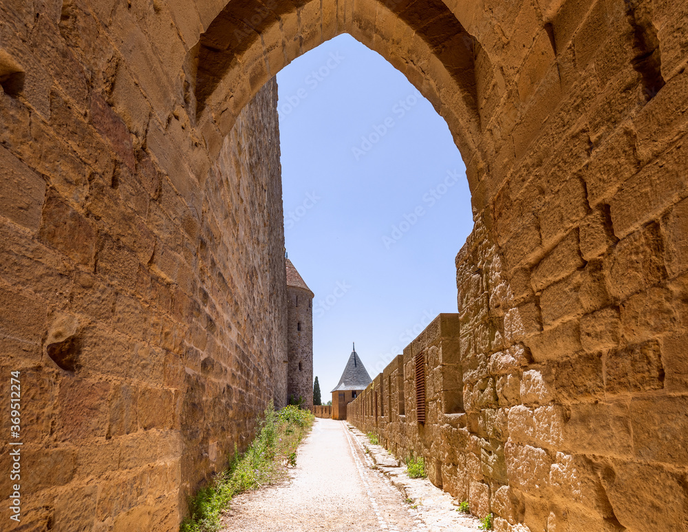 Wide fortified walls with walkways and arches of medieval castle of Carcassonne town