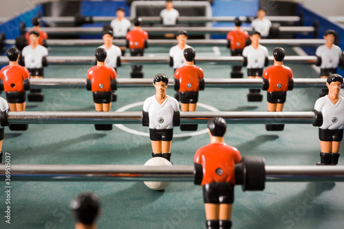 Indoor foosball table with white team vs. red team. Detail of table soccer attackers and defenders
