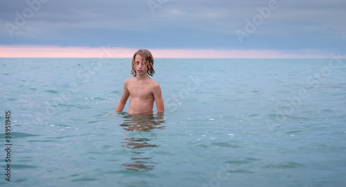 Young teenage boy enjoys the sea at the beach.