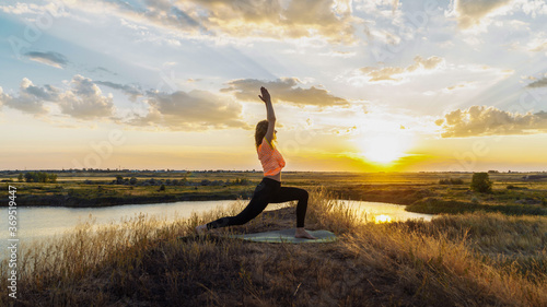 Young blonde woman making yoga outdoors.