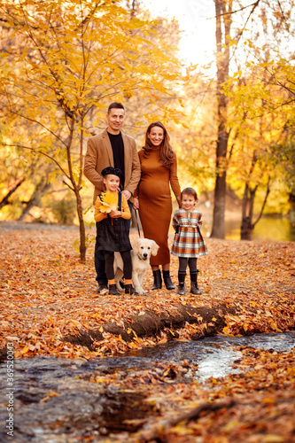 family with Retriever walking in autumn Park.
