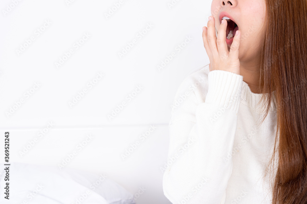 Asian woman are yawning covering open mouth with hand after she wake up. Healthcare medical or daily life concept. Asian woman are yawning covering open mouth with hand after she wake up. Healthcare medical or daily life concept.