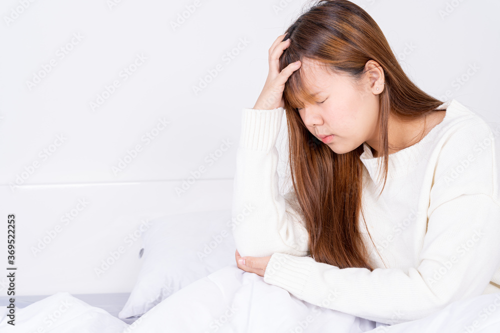 Young woman suffering from headaches after wake up on the bed. Healthcare medical or daily life concept. Young woman suffering from headaches after wake up on the bed. Healthcare medical or daily life concept.
