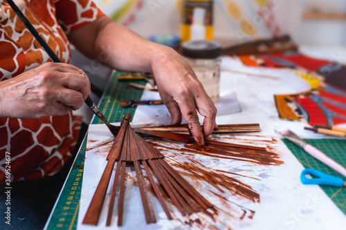 Schilderij op canvas una mujer artesana pinta a mano el armazon de un abanico español en un taller de