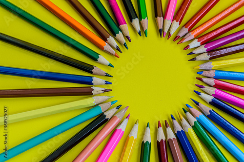 colored pencils on a yellow background copy space close-up