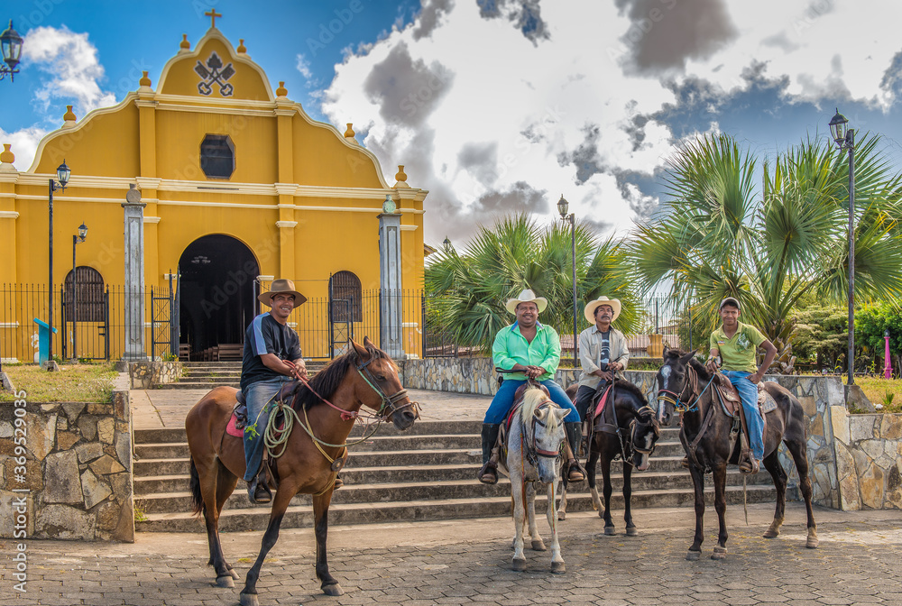 Naklejka premium 4 men on horseback in front of The Church of San Pedro, In the center of Diria, a small town near Granada Nicaragua 