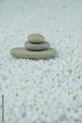 Pyramids of gray and white zen pebble meditation stones on white background. Concept of harmony, balance and meditation, spa, massage, relax
