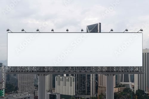 Blank white road billboard with KL cityscape background at day time. Street advertising poster, mock up, 3D rendering. Front view. The concept of marketing communication to promote or sell idea.