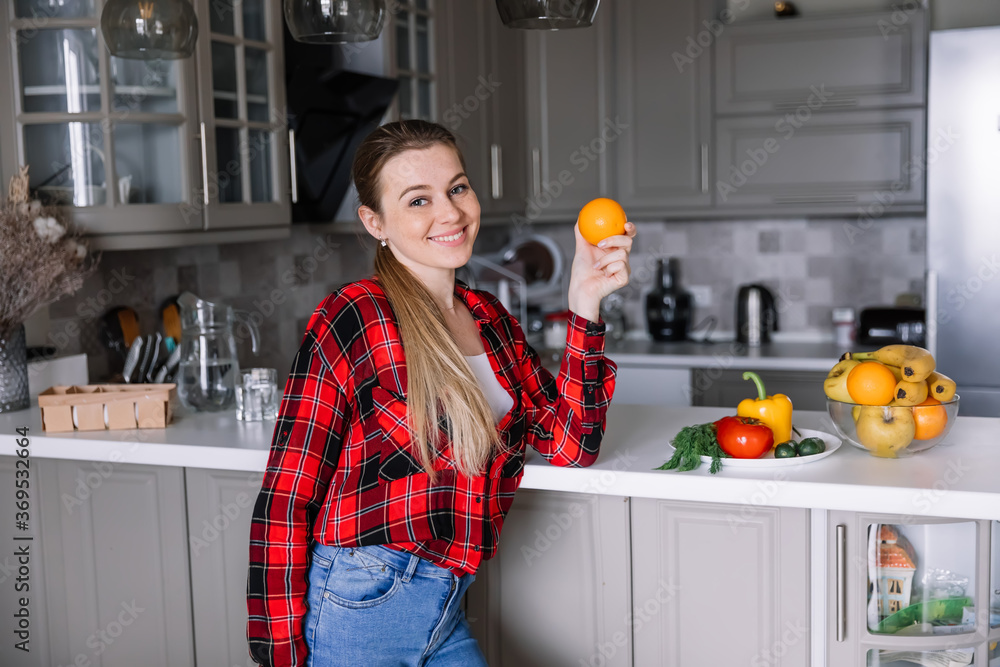 Portrait of young woman in kitchen with vegetables. Healthy food. Vegetables diet.