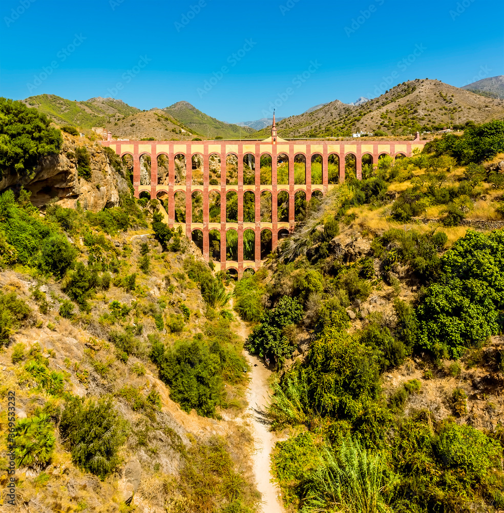 A vertical panorama of the majestic, four storey, Eagle Aqueduct that spans the ravine of Cazadores near Nerja, Spain in the summertime