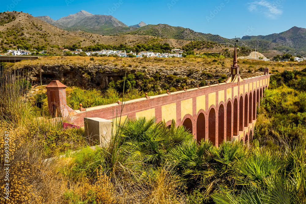 A view along the top storey of the majestic, four storey, Eagle Aqueduct that spans the ravine of Cazadores near Nerja, Spain in the summertime