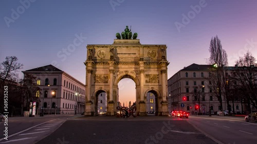 Germany, Munich - The Siegestor Victory Arch at sunset with traffic going around the arch day to night transition timelapse photo