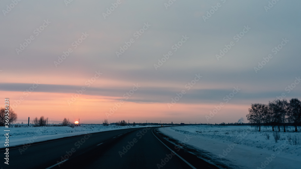 Winter highway with the setting sun in Siberia