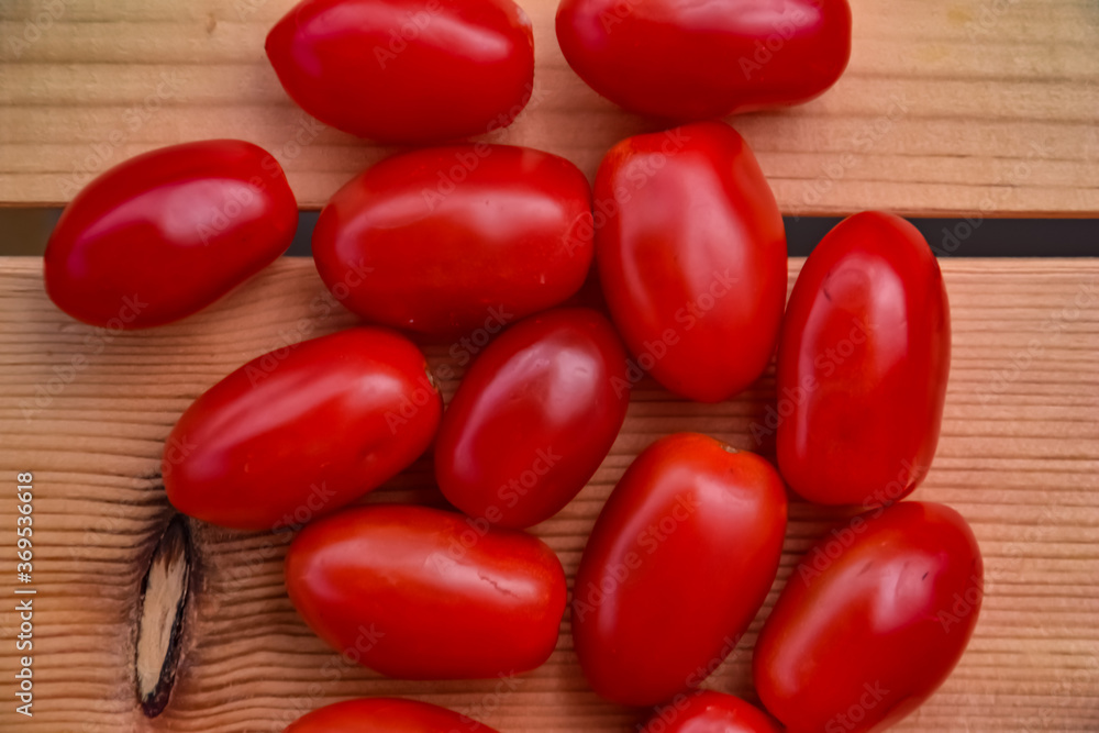 Fresh plum tomatoes on wood rustic background with natural shadow. Top view Fresh plum tomatoes on wood rustic background with natural shadow. Top view