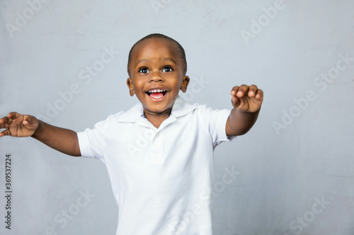 adorable preschool boy with hsi arms raised in happiness photo