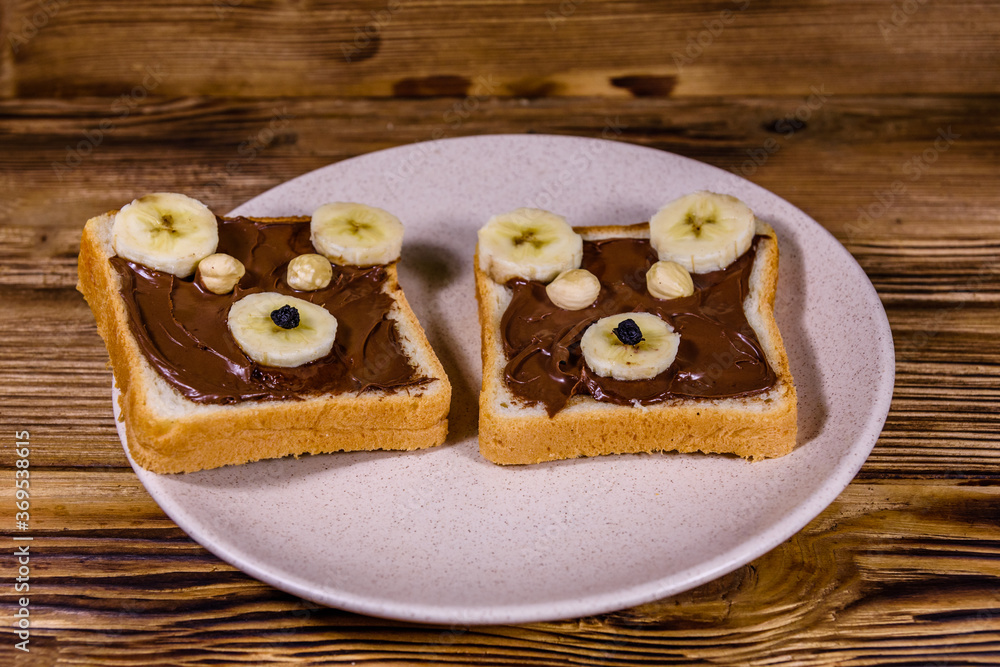 Two sandwiches with chocolate spread on a plate. Sandwich like a bear muzzle Two sandwiches with chocolate spread on a plate. Sandwich like a bear muzzle