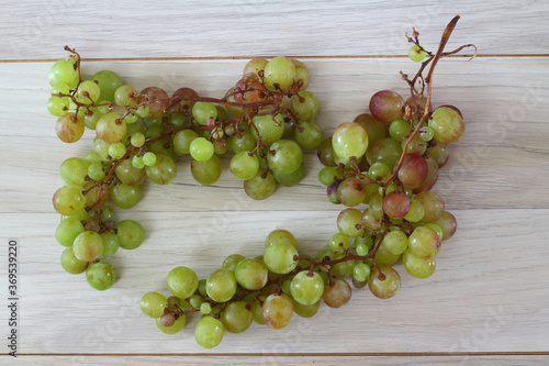green grapes with leaves on a old wooden background. Top view , copy space .