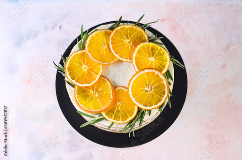 Beautiful delicious cake with sprigs of rosemary and orange frips. Delicious New Year's dessert. Biscuit cakes photo