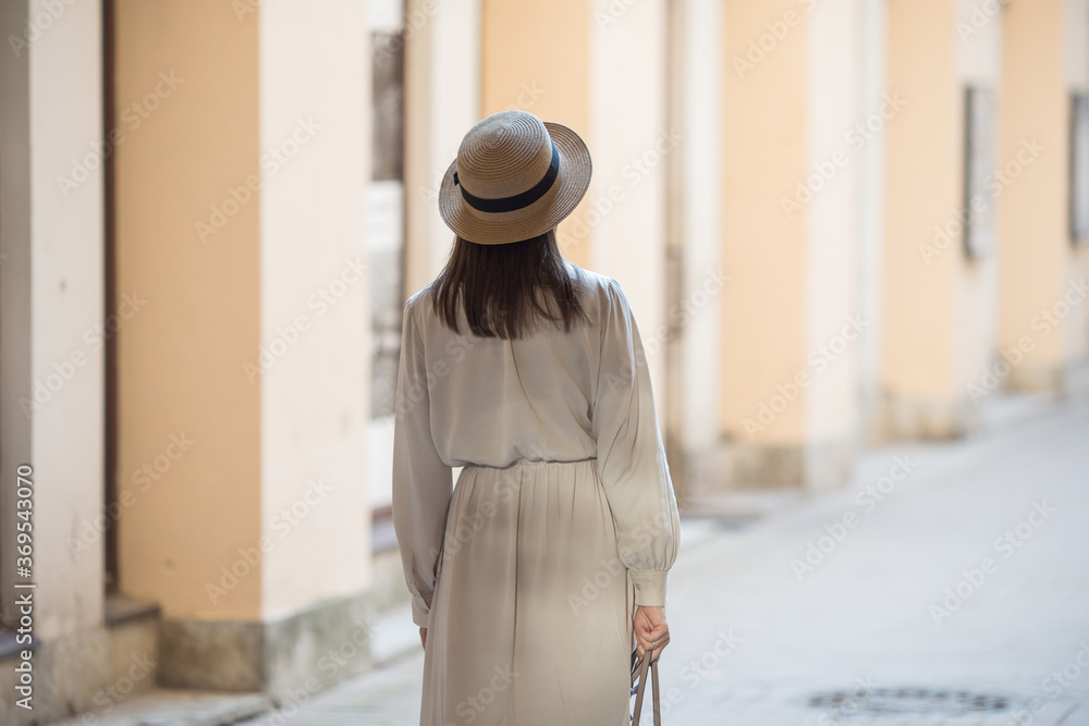 A young girl walks through the streets of the old city. Foreigner travel across St. Petersburg, Russia. Romantic walks along the vintage streets.