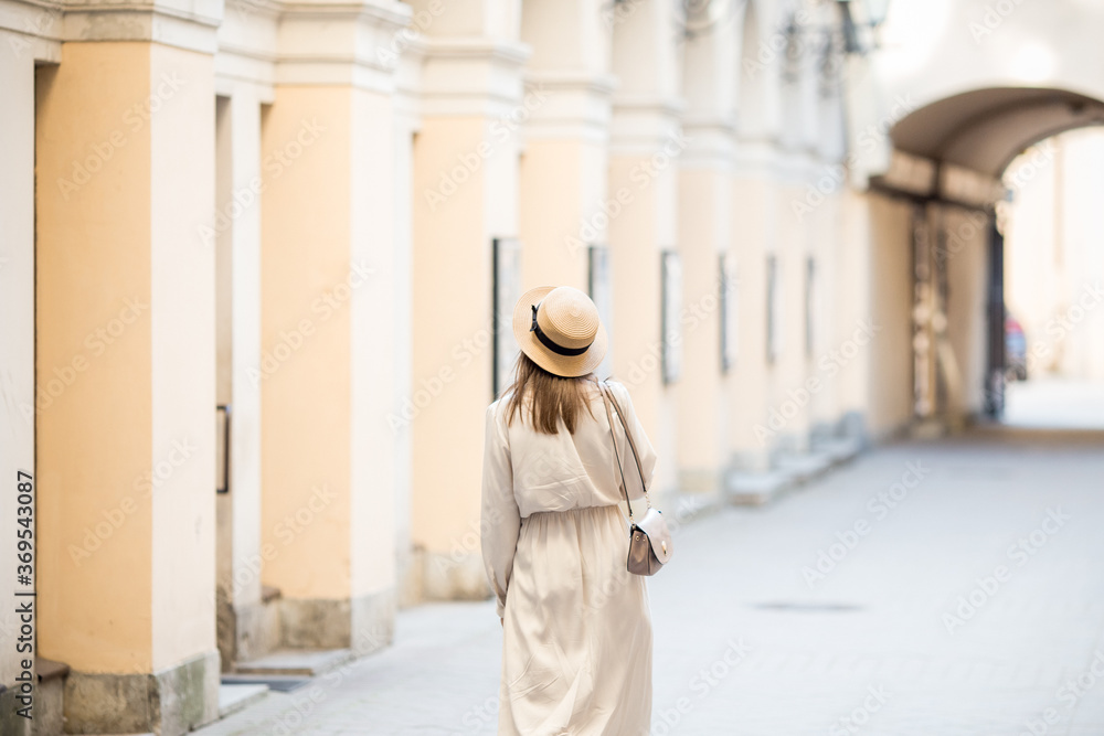 A young girl walks through the streets of the old city. Foreigner travel across St. Petersburg, Russia. Romantic walks along the vintage streets.