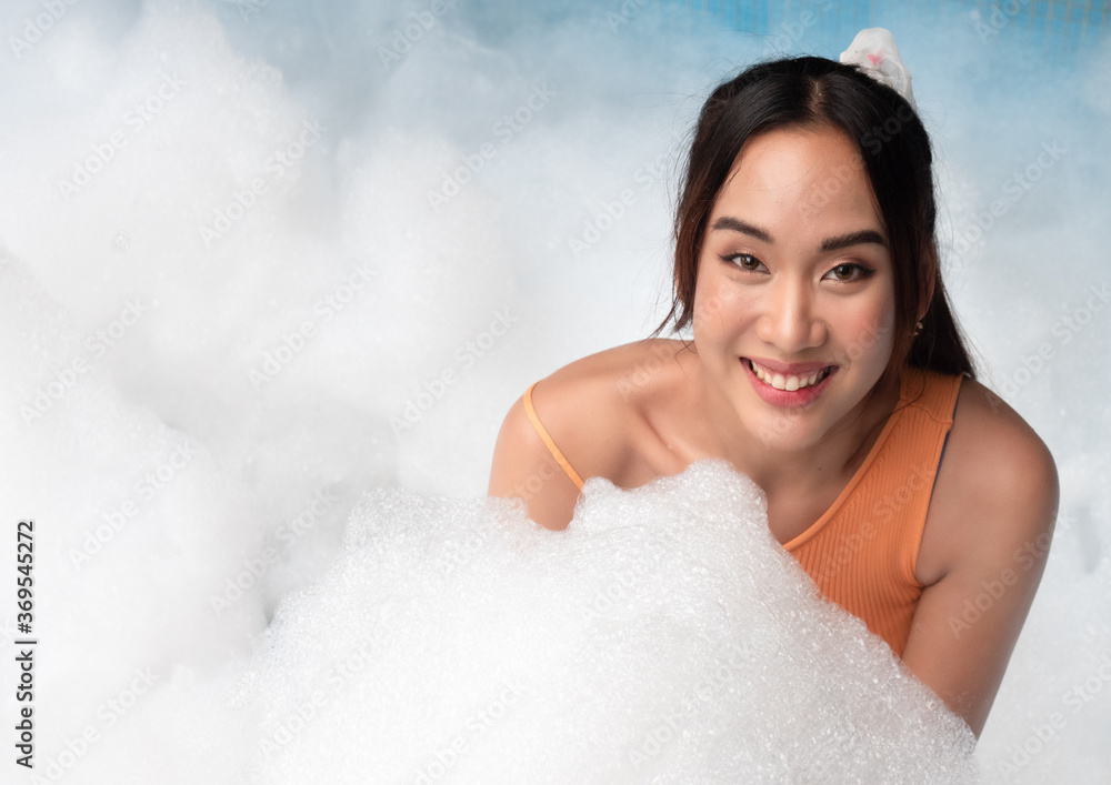 Portrait of pretty young woman in bikini having fun on soap foam disco party in the swimming pool.. Portrait of pretty young woman in bikini having fun on soap foam disco party in the swimming pool..
