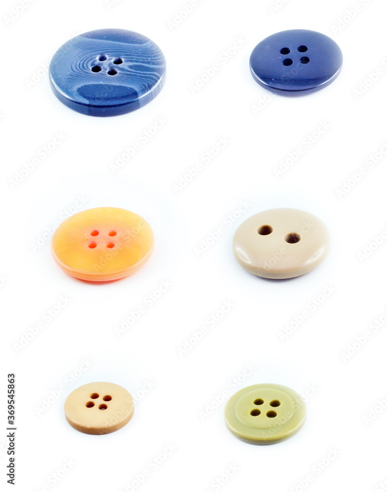 Six buttons in different colors and shapes and sizes. Blue, yellow, white, beige and green buttons. Isolated against a white background. Six buttons in different colors and shapes and sizes. Blue, yellow, white, beige and green buttons. Isolated against a white background.