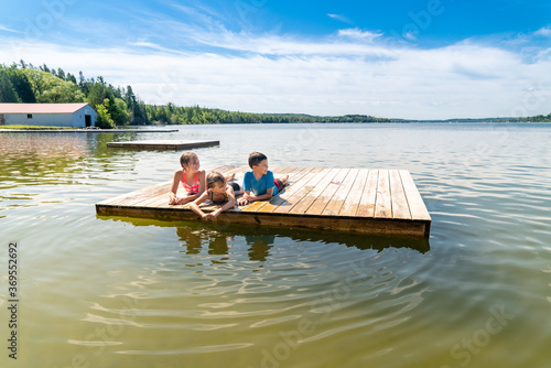 Children laying on a raft on a lake during summer